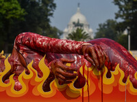 Activists of People for the Ethical Treatment of Animals (PETA) are seen drenched in fake blood and sleep on a figurative oven as they stage...