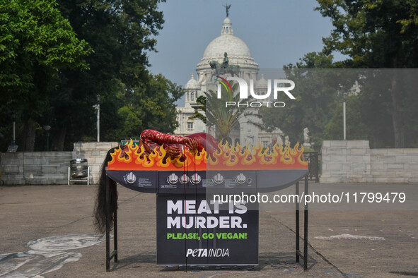 Activists of People for the Ethical Treatment of Animals (PETA) are seen drenched in fake blood and sleep on a figurative oven as they stage...