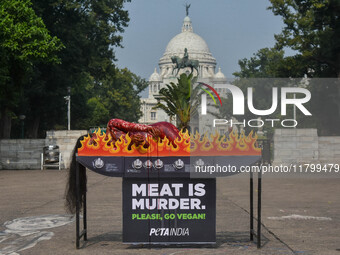 Activists of People for the Ethical Treatment of Animals (PETA) are seen drenched in fake blood and sleep on a figurative oven as they stage...