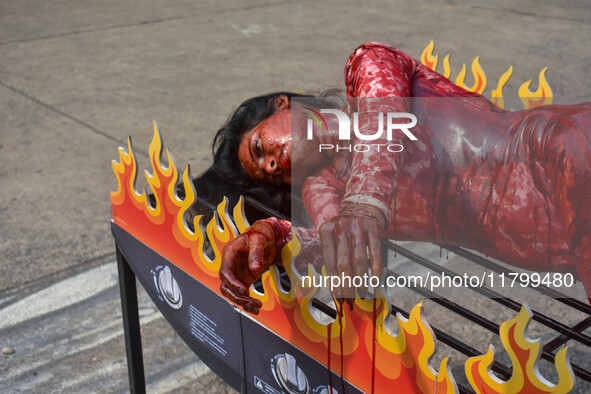 Activists of People for the Ethical Treatment of Animals (PETA) are seen drenched in fake blood and sleep on a figurative oven as they stage...