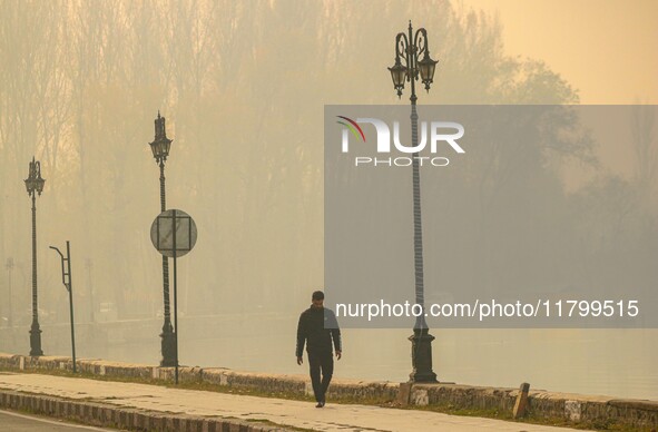 A man walks on the banks of Dal Lake amid fog in Srinagar, Jammu and Kashmir, on November 22, 2024. 