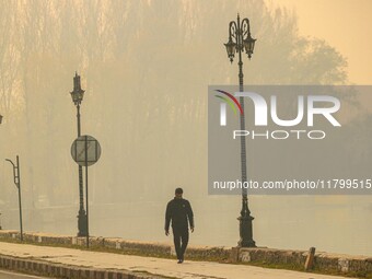 A man walks on the banks of Dal Lake amid fog in Srinagar, Jammu and Kashmir, on November 22, 2024. (