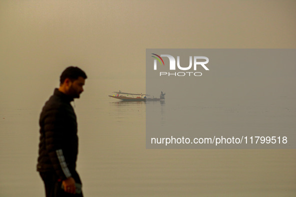 A man rows his boat in the waters of Dal Lake amid fog in Srinagar, Jammu and Kashmir, on November 22, 2024. 