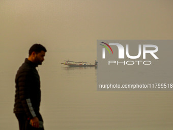 A man rows his boat in the waters of Dal Lake amid fog in Srinagar, Jammu and Kashmir, on November 22, 2024. (