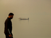 A man rows his boat in the waters of Dal Lake amid fog in Srinagar, Jammu and Kashmir, on November 22, 2024. (