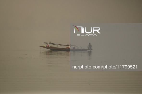 A man rows his boat in the waters of Dal Lake amid fog in Srinagar, Jammu and Kashmir, on November 22, 2024. 