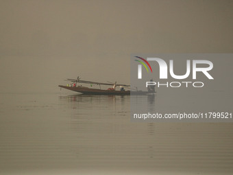 A man rows his boat in the waters of Dal Lake amid fog in Srinagar, Jammu and Kashmir, on November 22, 2024. (