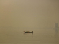 A man rows his boat in the waters of Dal Lake amid fog in Srinagar, Jammu and Kashmir, on November 22, 2024. (