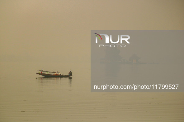 A fisherman smokes hookah in the Dal Lake amid fog in Srinagar, Jammu and Kashmir, on November 22, 2024. 