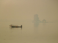 A fisherman smokes hookah in the Dal Lake amid fog in Srinagar, Jammu and Kashmir, on November 22, 2024. (