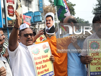 Supporters of India's main opposition Congress party take part in a protest rally with an effigy against the Indian billionaire businessman...