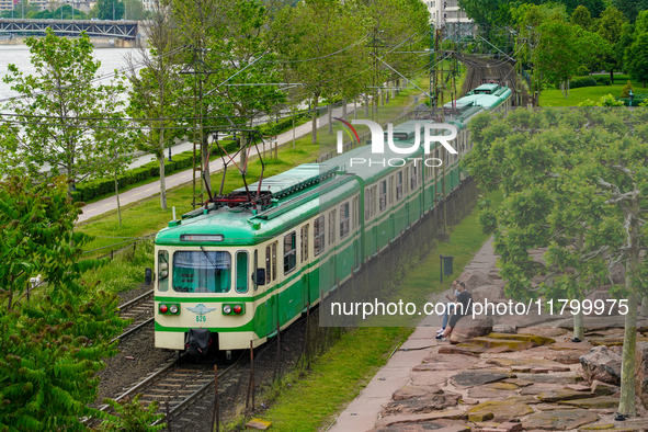 A suburban train runs alongside the Danube River near Mupa-Nemzeti Szinhaz station in Budapest, Hungary, on May 19, 2023. The train glides t...