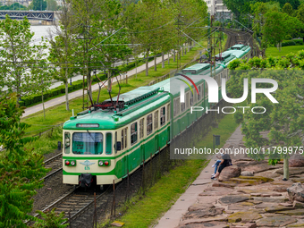 A suburban train runs alongside the Danube River near Mupa-Nemzeti Szinhaz station in Budapest, Hungary, on May 19, 2023. The train glides t...