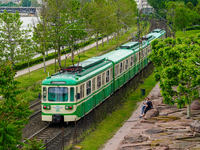 A suburban train runs alongside the Danube River near Mupa-Nemzeti Szinhaz station in Budapest, Hungary, on May 19, 2023. The train glides t...