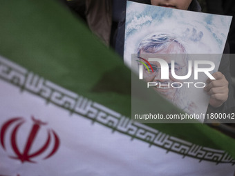 A young Iranian boy holds a portrait of Lebanon's Hezbollah leader, Hassan Nasrallah, who was killed in an Israeli airstrike in a suburb of...