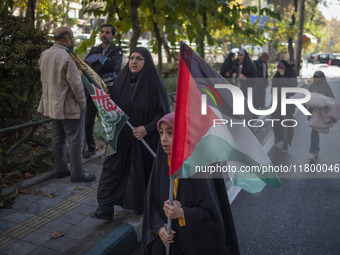 A veiled Iranian girl carries a Palestinian flag while participating in an anti-Israeli rally in front of the United Nations (UN) office in...