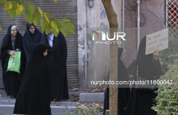 A veiled Iranian woman carries an anti-UN placard while arriving to participate in an anti-Israeli rally in front of the United Nations offi...