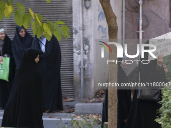 A veiled Iranian woman carries an anti-UN placard while arriving to participate in an anti-Israeli rally in front of the United Nations offi...