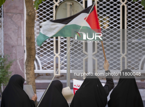 A veiled Iranian woman waves a Palestinian flag while participating in an anti-Israeli rally in front of the United Nations (UN) office in n...