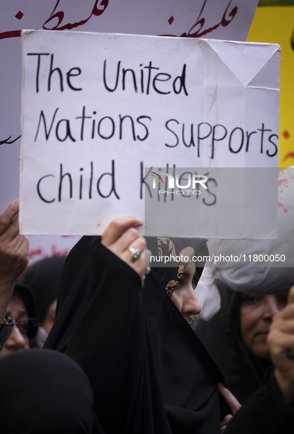 A veiled Iranian woman holds up an anti-UN placard while participating in an anti-Israeli rally in front of the United Nations office in nor...