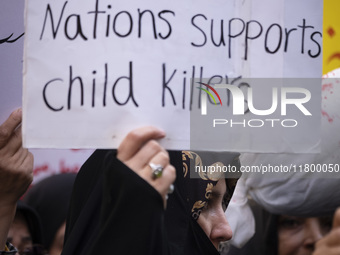 A veiled Iranian woman holds up an anti-UN placard while participating in an anti-Israeli rally in front of the United Nations office in nor...