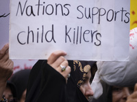 A veiled Iranian woman holds up an anti-UN placard while participating in an anti-Israeli rally in front of the United Nations office in nor...