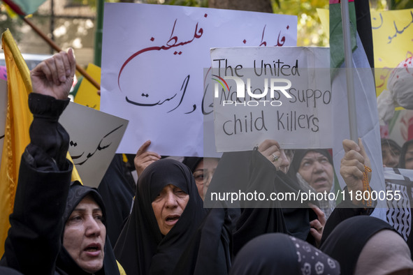 A veiled Iranian woman holds up an anti-UN placard while participating in an anti-Israeli rally in front of the United Nations office in nor...