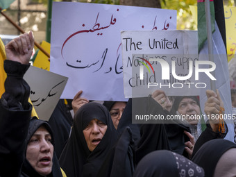 A veiled Iranian woman holds up an anti-UN placard while participating in an anti-Israeli rally in front of the United Nations office in nor...