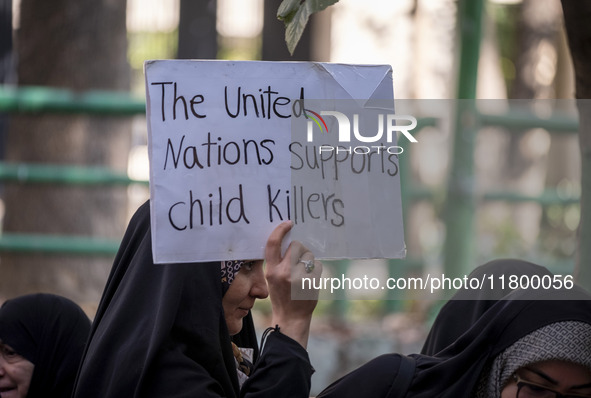 A veiled Iranian woman holds up an anti-UN placard while participating in an anti-Israeli rally in front of the United Nations office in nor...