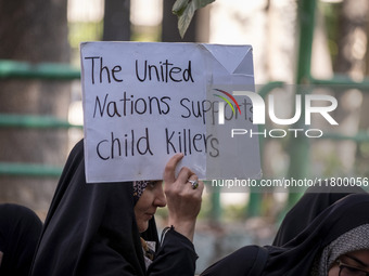 A veiled Iranian woman holds up an anti-UN placard while participating in an anti-Israeli rally in front of the United Nations office in nor...