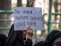 A veiled Iranian woman holds up an anti-UN placard while participating in an anti-Israeli rally in front of the United Nations office in nor...