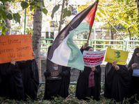 Veiled Iranian women hold portraits of Lebanon's Hezbollah leader, Hassan Nasrallah, a placard, and a Palestinian flag while participating i...