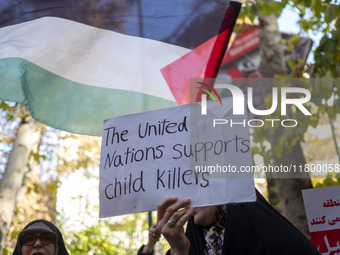 A veiled Iranian woman holds up an anti-UN placard while participating in an anti-Israeli rally in front of the United Nations office in nor...