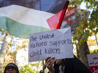 A veiled Iranian woman holds up an anti-UN placard while participating in an anti-Israeli rally in front of the United Nations office in nor...