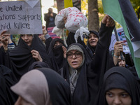 A veiled Iranian woman shouts anti-UN slogans while another woman holds up an anti-UN placard during an anti-Israeli rally in front of the U...