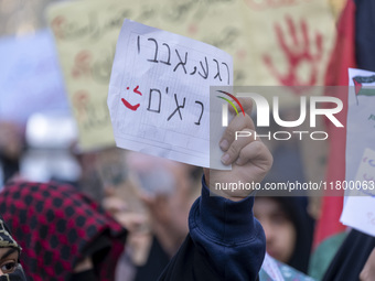 A veiled Iranian woman wearing a Palestinian scarf holds up an anti-Israeli placard that reads, ''Keep waiting, we are coming,'' during an a...