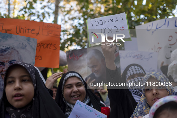 A veiled Iranian woman wearing a Palestinian scarf holds up an anti-Israeli placard that reads, ''Keep waiting, we are coming,'' during an a...