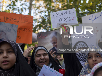 A veiled Iranian woman wearing a Palestinian scarf holds up an anti-Israeli placard that reads, ''Keep waiting, we are coming,'' during an a...