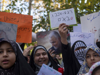 A veiled Iranian woman wearing a Palestinian scarf holds up an anti-Israeli placard that reads, ''Keep waiting, we are coming,'' during an a...