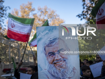 Iranian protesters wave Iranian flags and hold up a portrait of Lebanon's Hezbollah late leader, Hassan Nasrallah, who was killed in an Isra...