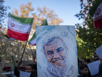 Iranian protesters wave Iranian flags and hold up a portrait of Lebanon's Hezbollah late leader, Hassan Nasrallah, who was killed in an Isra...