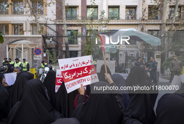 Veiled Iranian women wave a Palestinian flag and hold up an anti-U.S. placard during an anti-Israeli rally in front of the United Nations of...