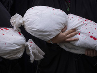 A veiled young Iranian girl holds a package wrapped in a shroud, symbolizing the body of a Palestinian child, during an anti-Israeli rally i...