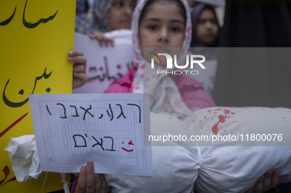 A young veiled girl holds an anti-Israeli placard that reads, ''Keep waiting, we are coming,'' and a package wrapped in a shroud, symbolizin...