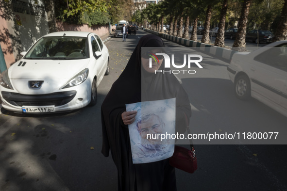 A veiled Iranian woman carries a portrait of Lebanon's Hezbollah late leader, Hassan Nasrallah, who was killed in an Israeli airstrike in a...