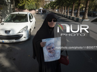 A veiled Iranian woman carries a portrait of Lebanon's Hezbollah late leader, Hassan Nasrallah, who was killed in an Israeli airstrike in a...