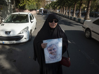 A veiled Iranian woman carries a portrait of Lebanon's Hezbollah late leader, Hassan Nasrallah, who was killed in an Israeli airstrike in a...