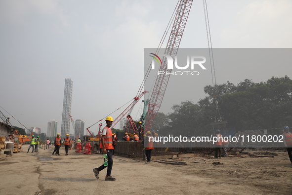 Labourers work at a metro railway station construction site in Kolkata, India, on November 22, 2024. 