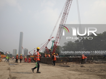 Labourers work at a metro railway station construction site in Kolkata, India, on November 22, 2024. (