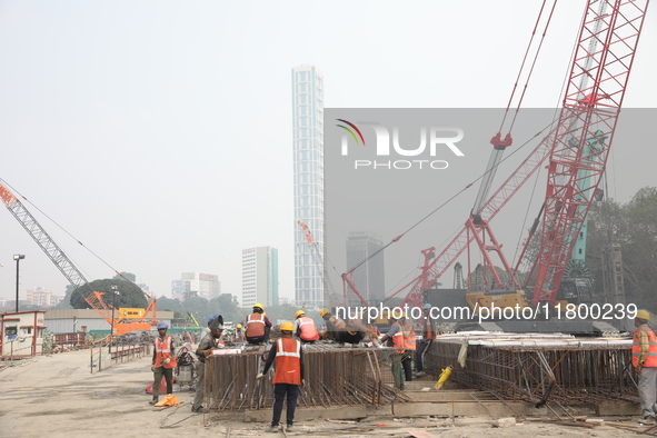 Labourers work at a metro railway station construction site in Kolkata, India, on November 22, 2024. 